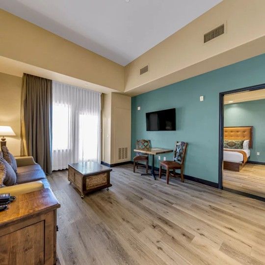 A hotel room with a couch , table and chairs