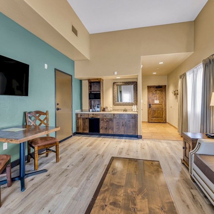 A living room with a table and chairs and a flat screen tv