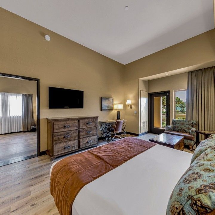 A hotel room with a large bed and a flat screen tv