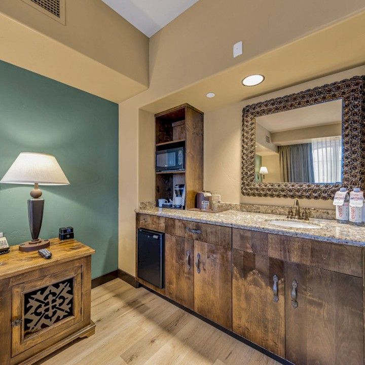 A hotel room with a sink and a mirror