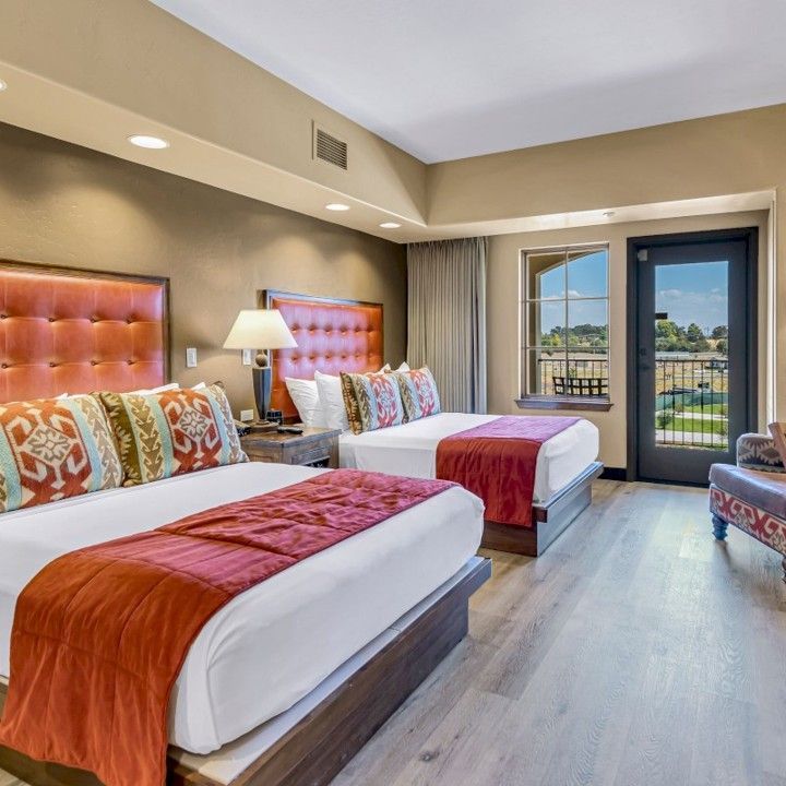 A hotel room with two beds and a chair