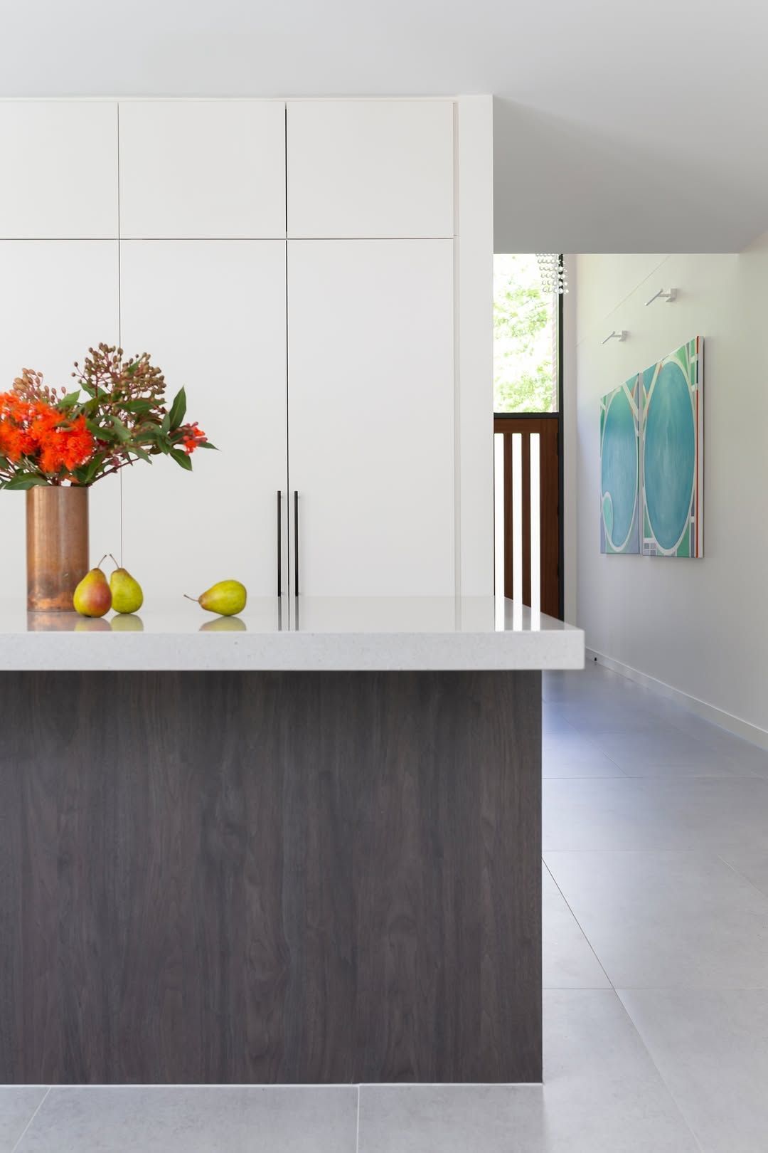 Modern Kitchen With White Cabinets, Dark Island, and Flowers — Complete Property Projects in Phillip, ACT