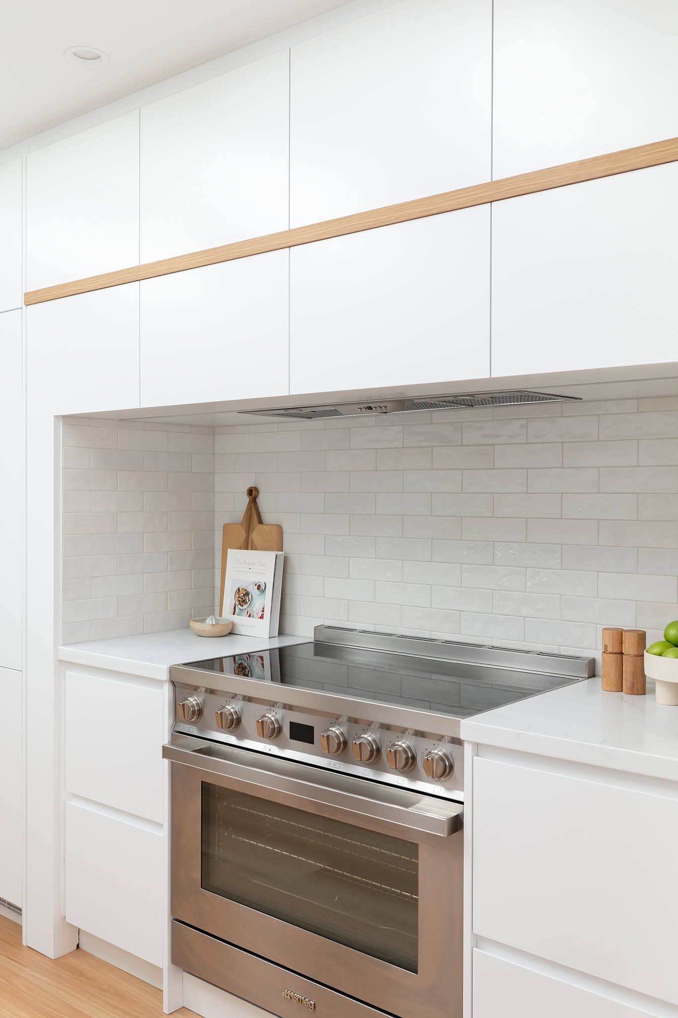 Modern White Kitchen with Stainless Steel Stove, Built-In Cabinets, and Tiled Backsplash — Complete Property Projects In Phillip, ACT