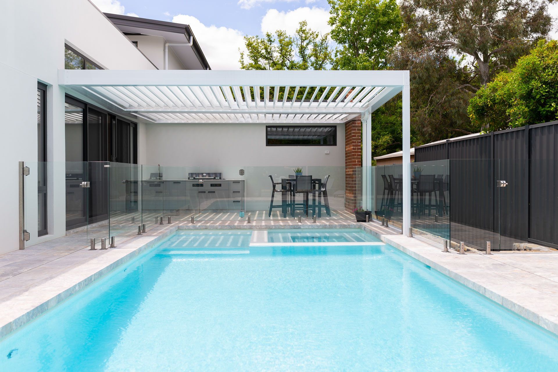 Modern Backyard Pool with Turquoise Water Beside a Covered Patio — Complete Property Projects In Phillip, ACT