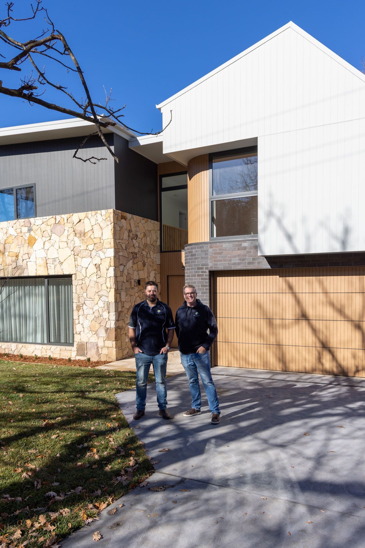 Two People Walking on A Driveway in Front of A Modern House — Complete Property Projects In Phillip, ACT