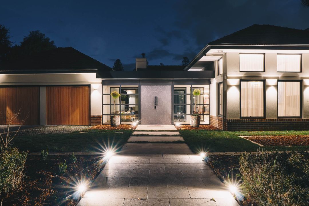 Modern House Exterior at Dusk with Illuminated Walkway — Complete Property Projects In Phillip, ACT