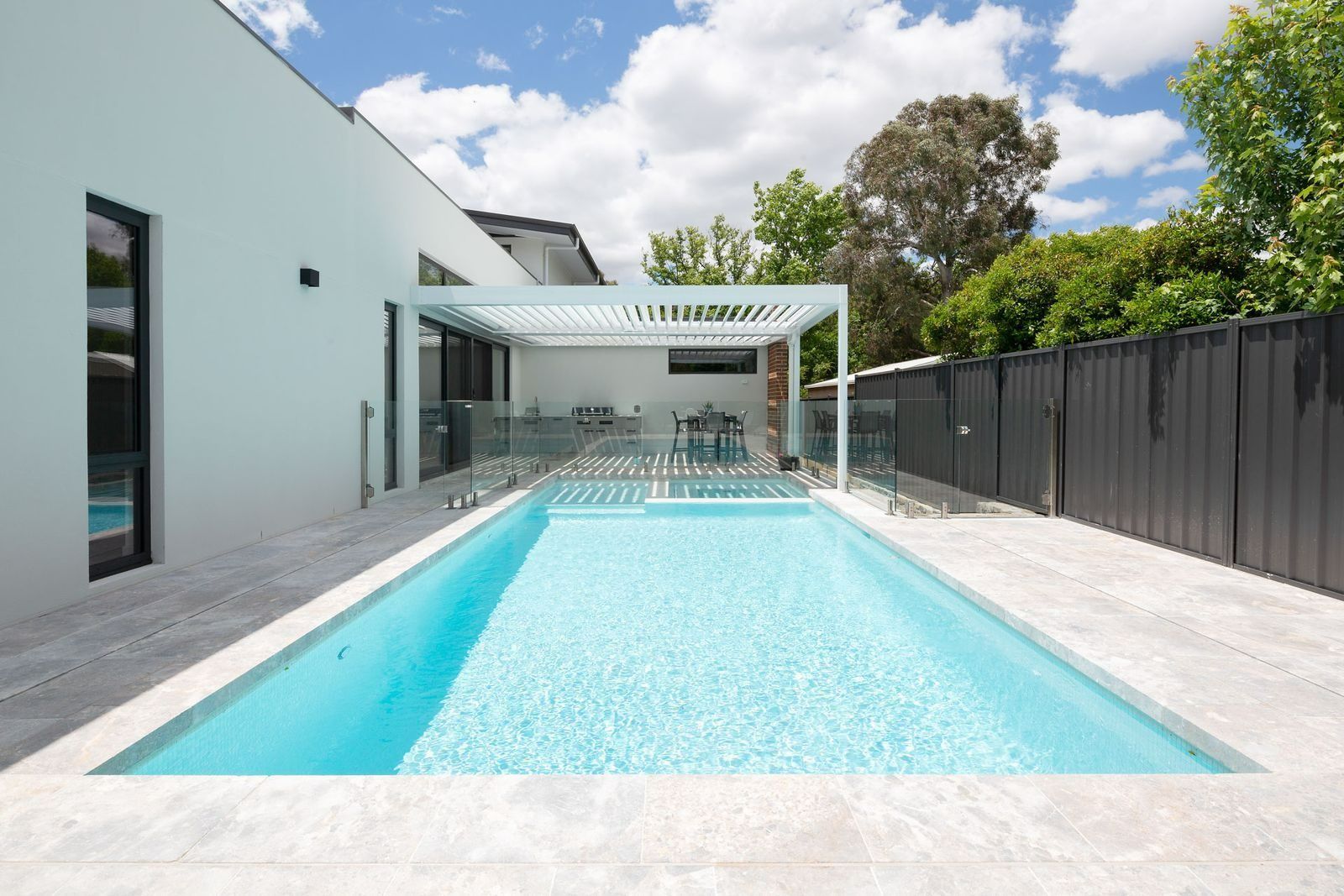Modern Backyard with A Turquoise Lap Pool Beside a White House — Complete Property Projects In Phillip, ACT