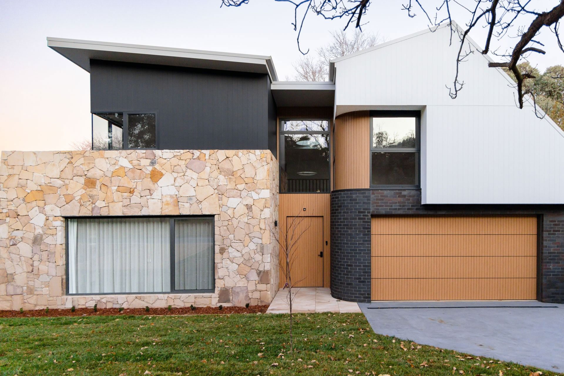 Modern Two-Story House Exterior with Stone and Dark Siding — Complete Property Projects In Phillip, ACT