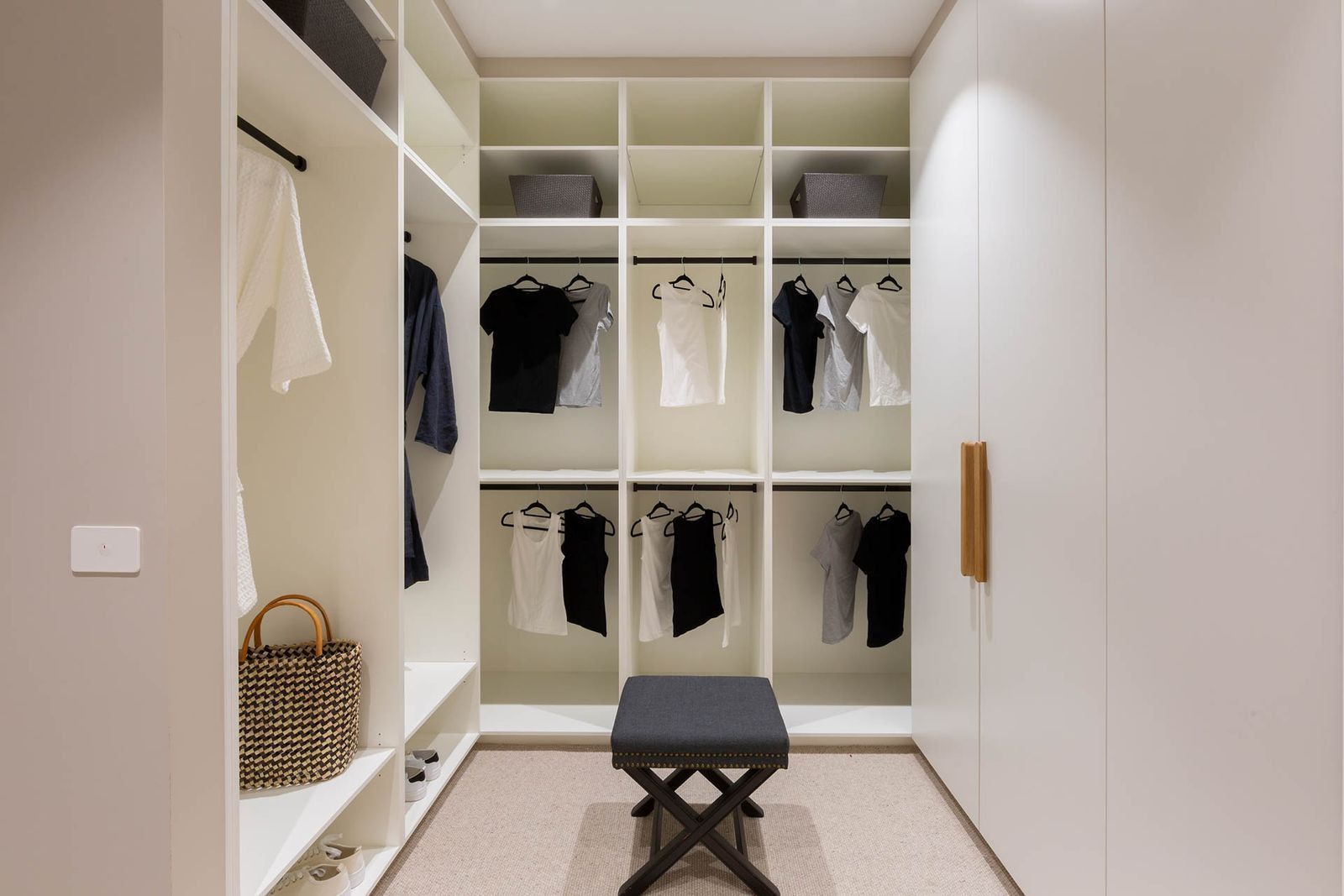 Walk-in Closet With White Shelves, Clothes, Bench, and Basket — Complete Property Projects in Phillip, ACT