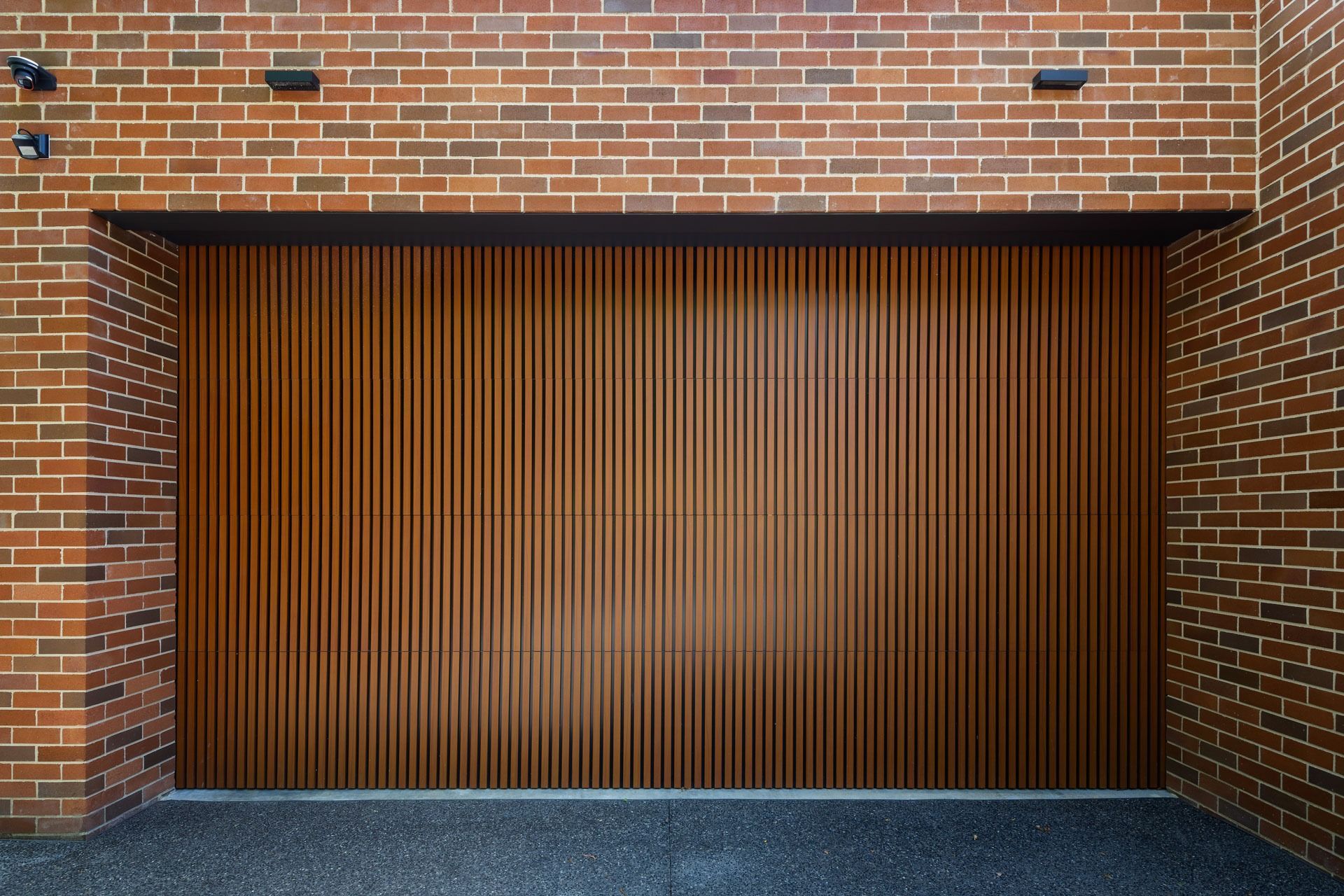 Brick Garage Facade with A Closed Wooden Slatted Door — Complete Property Projects In Phillip, ACT