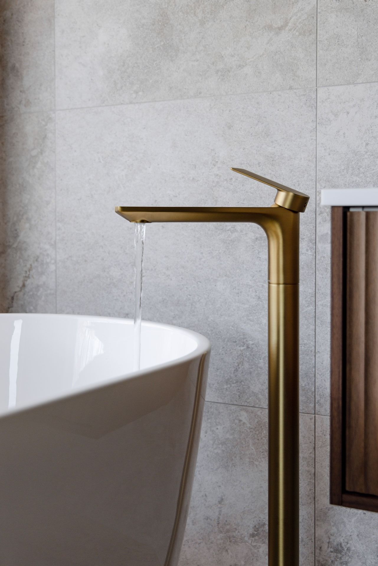 Gold Faucet Beside White Bathtub in A Modern Tiled Bathroom — Complete Property Projects In Phillip, ACT