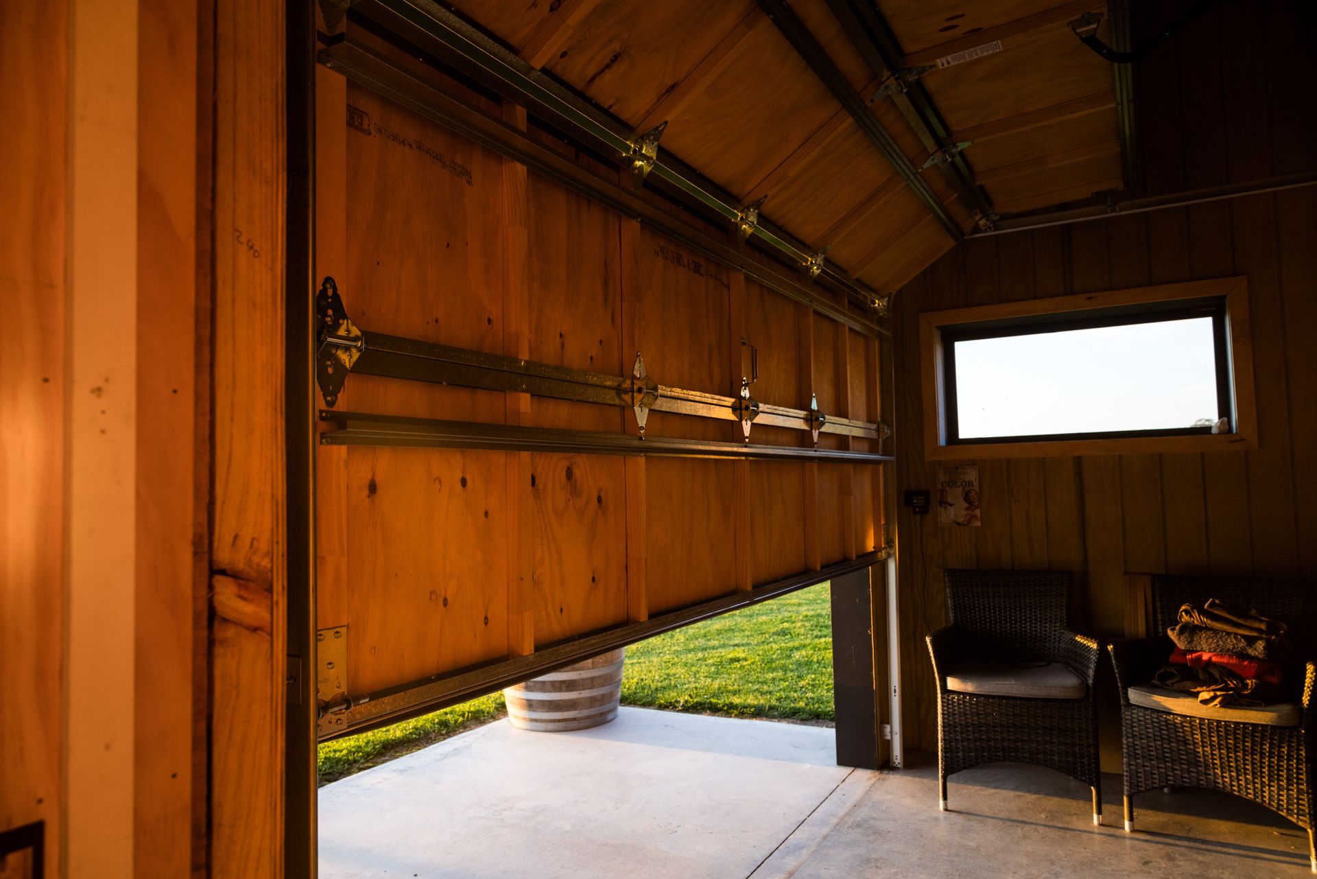 A wooden garage with the door open and a window