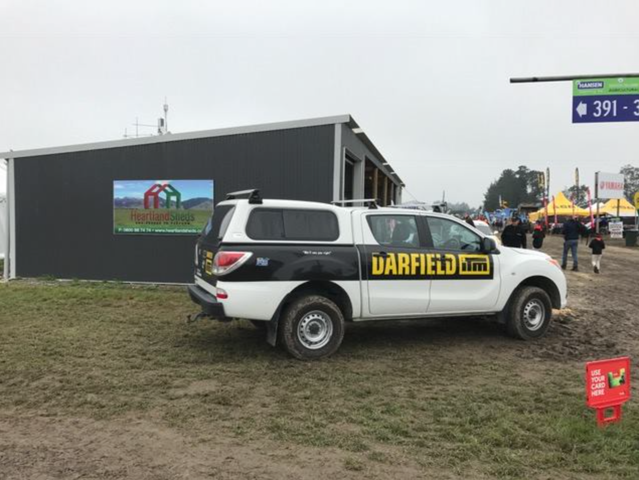 A white darfield truck is parked in front of a building.