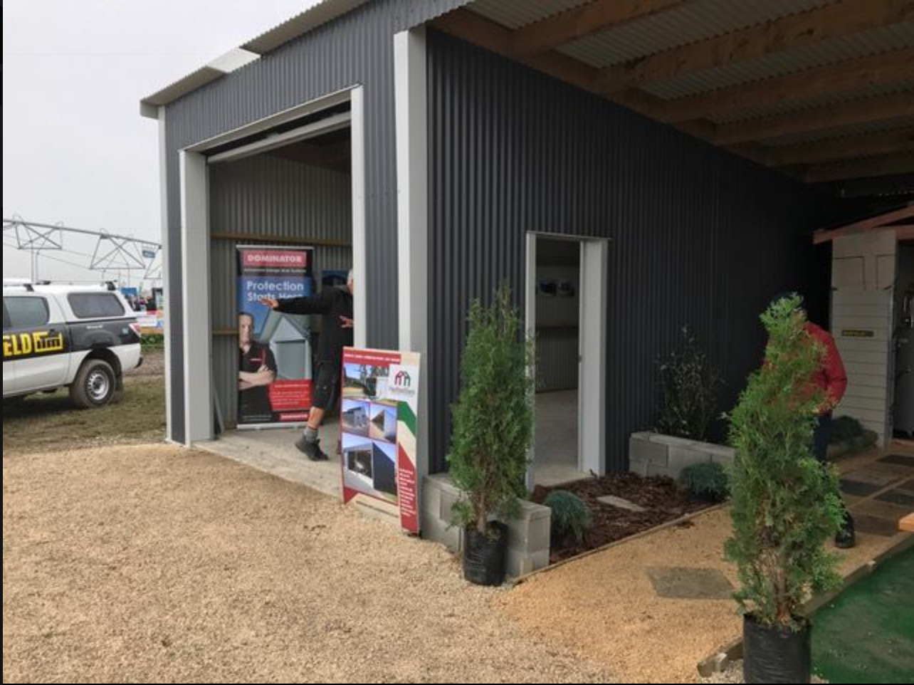 A man is walking into a garage with a sign that says ' adelaide ' on it.