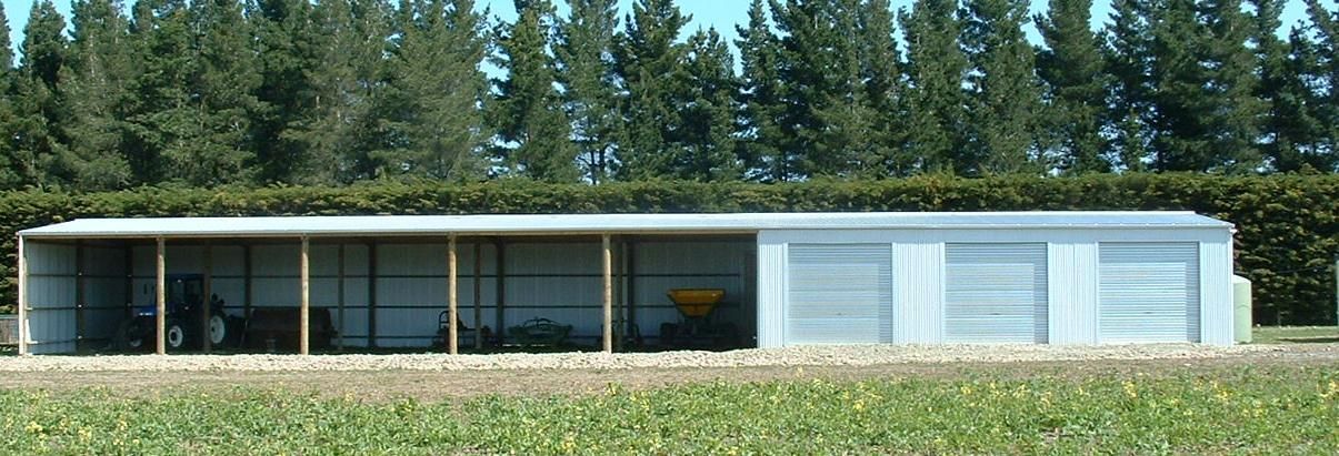 A shed in the middle of a field with trees in the background