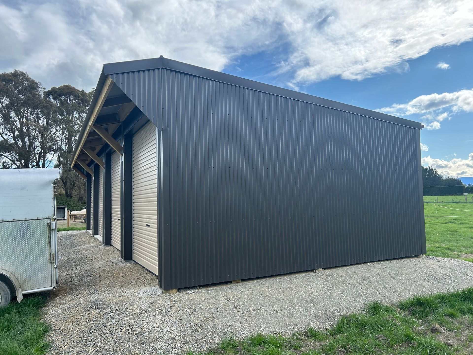 A shed is sitting in the middle of a grassy field.