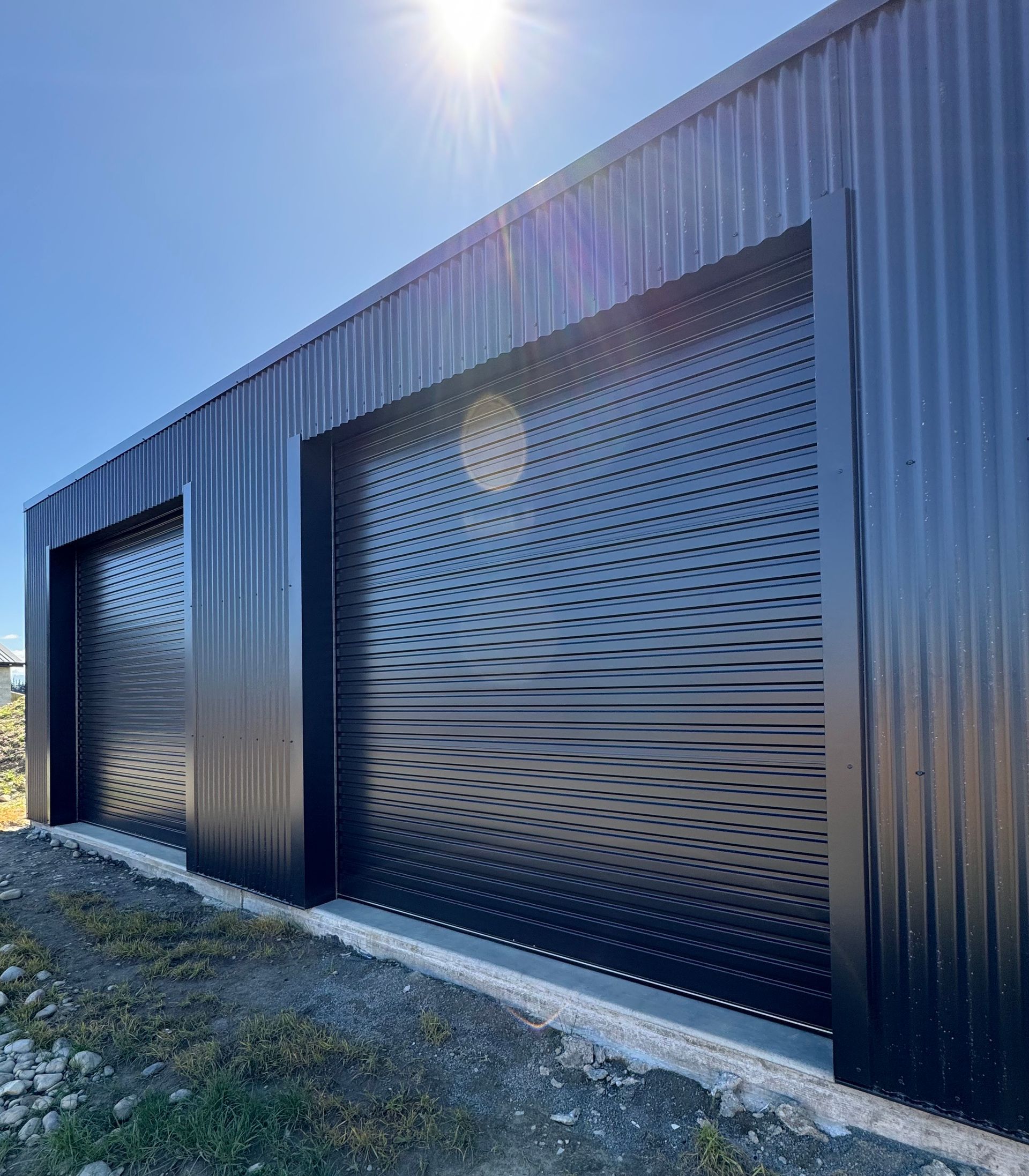 A black building with a lot of windows and a blue sky in the background.