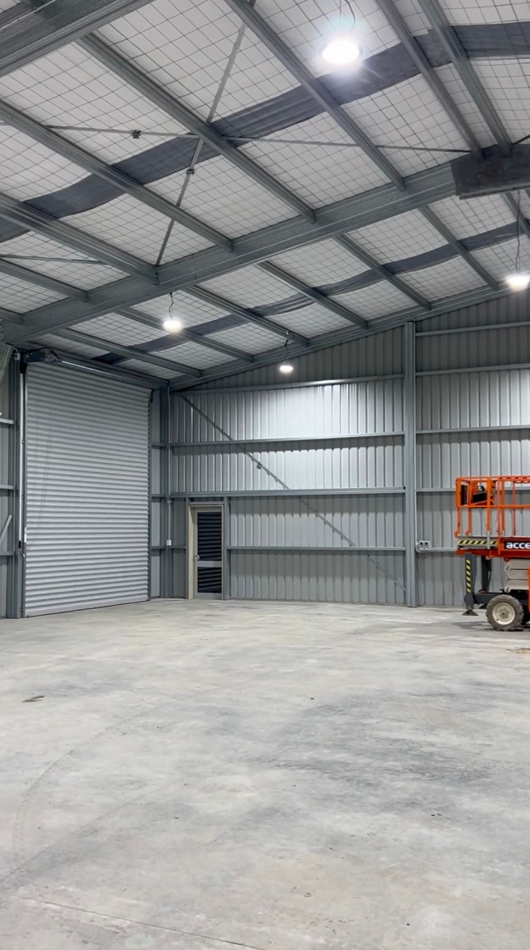 A large warehouse with a forklift inside of it.