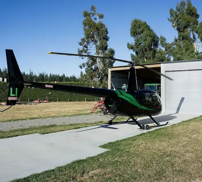 a black and green helicopter with the letter l on the tail
