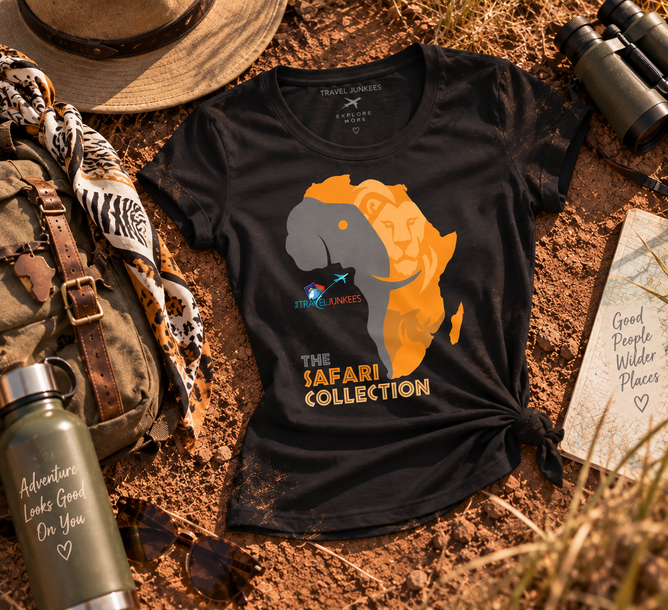 Black safari-themed T-shirt with orange lion graphic on a rustic outdoor flat lay