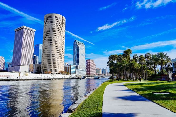 Tampa, Florida skyline from across Hillsborough River with waterfront park on a sunny day.