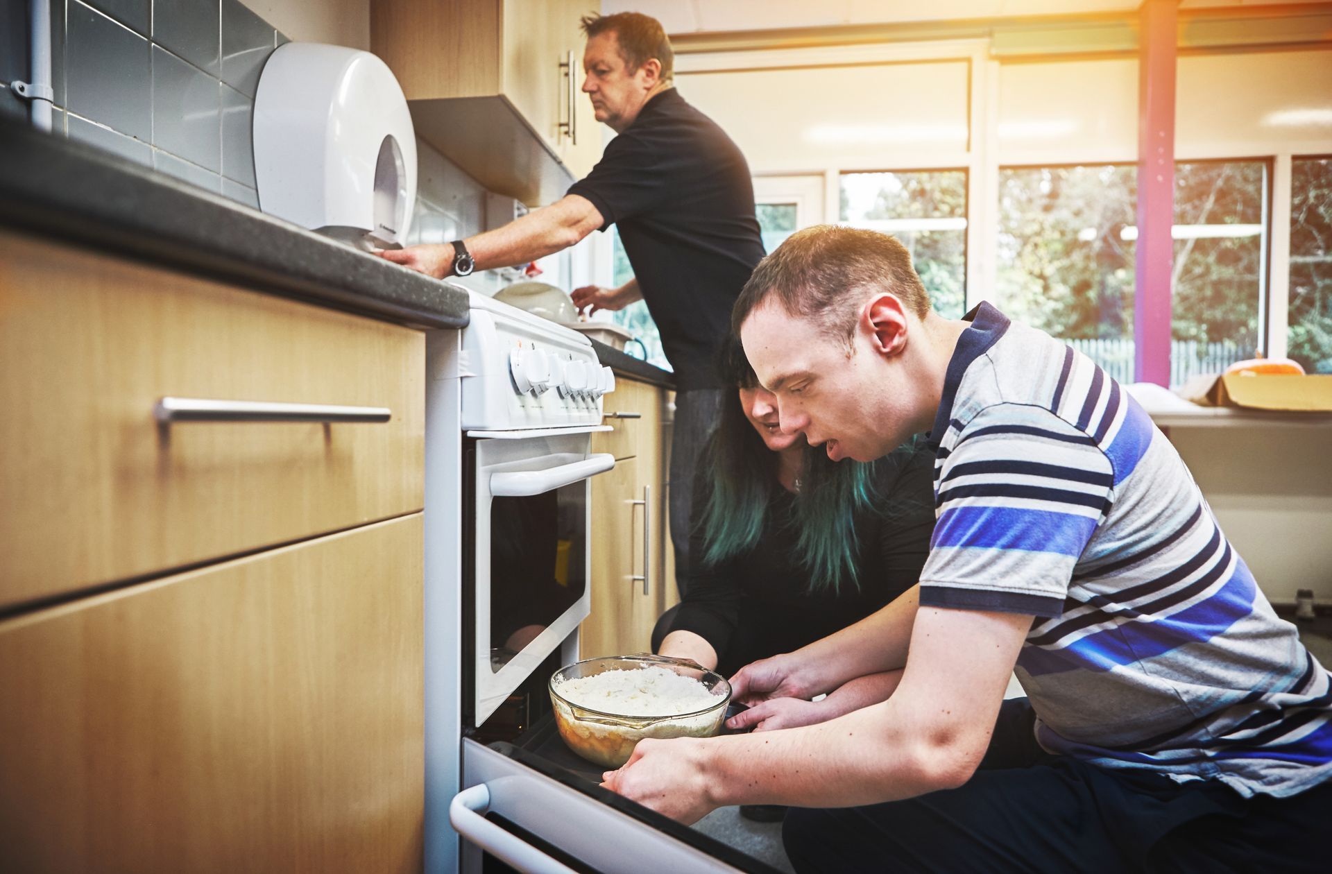 A man with disabilities is learning basic baking skills in a facility for people with special needs. A man with disabilities is learning basic baking skills in a facility for people with special needs.