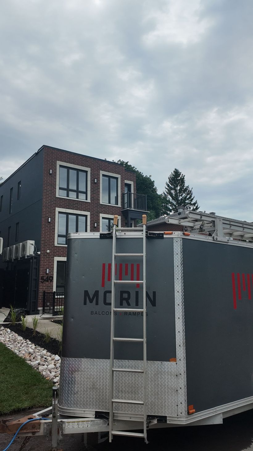 Deux immeubles d’habitation modernes en briques, dotés de grandes fenêtres et reliés par une allée centrale