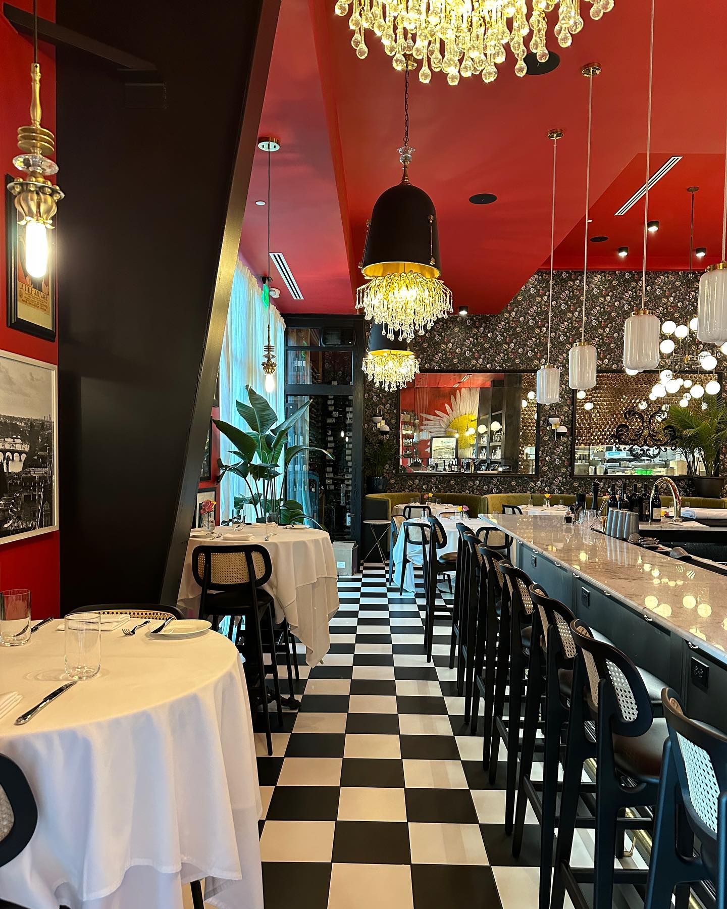 East End Bistrot Restaurant interior: black and white checkered floor, red ceiling, black bar stools, and white tablecloths.
