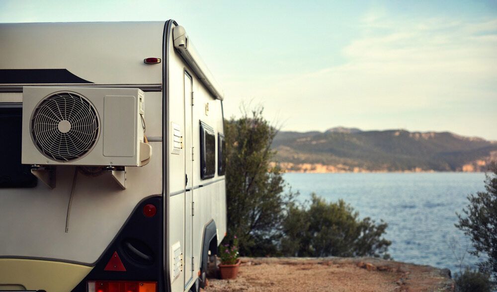 Caravan with Air Conditioning Unit on a Beach — Kilowatts & Cool Whitsundays In Airlie Beach, QLD