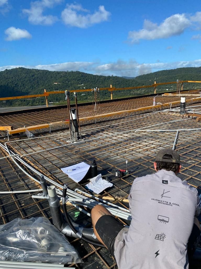 A Man is Sitting on Top of a Construction Site — Kilowatts & Cool Whitsundays In Cannonvale, QLD