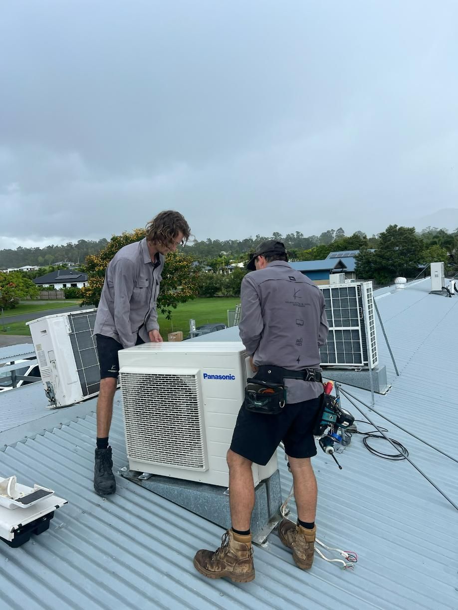 Two Men Are Working on An Air Conditioner on The Roof of A Building — Kilowatts & Cool Whitsundays In Strathdickie, QLD