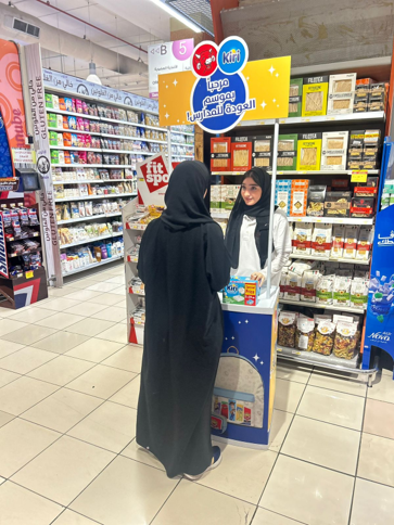 A woman in a hijab is talking to another woman in a store