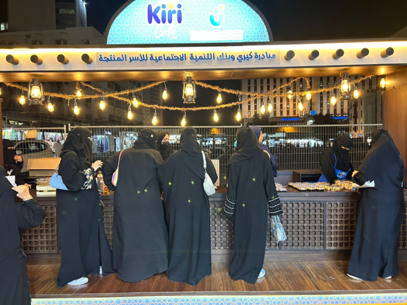 A group of women standing in front of a sign that says kiri