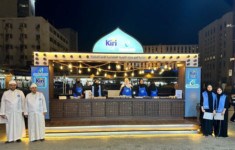 A group of people standing in front of a kiosk that says ' kuri ' on it