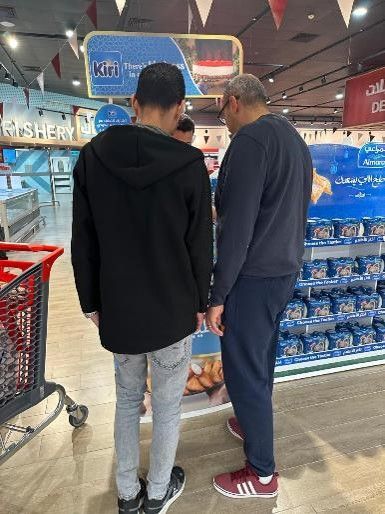 Two men are standing next to each other in a grocery store.