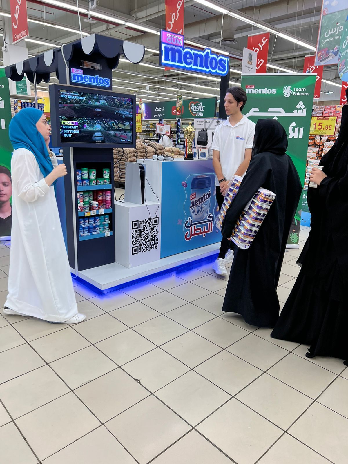A group of people standing in front of a mentos stand