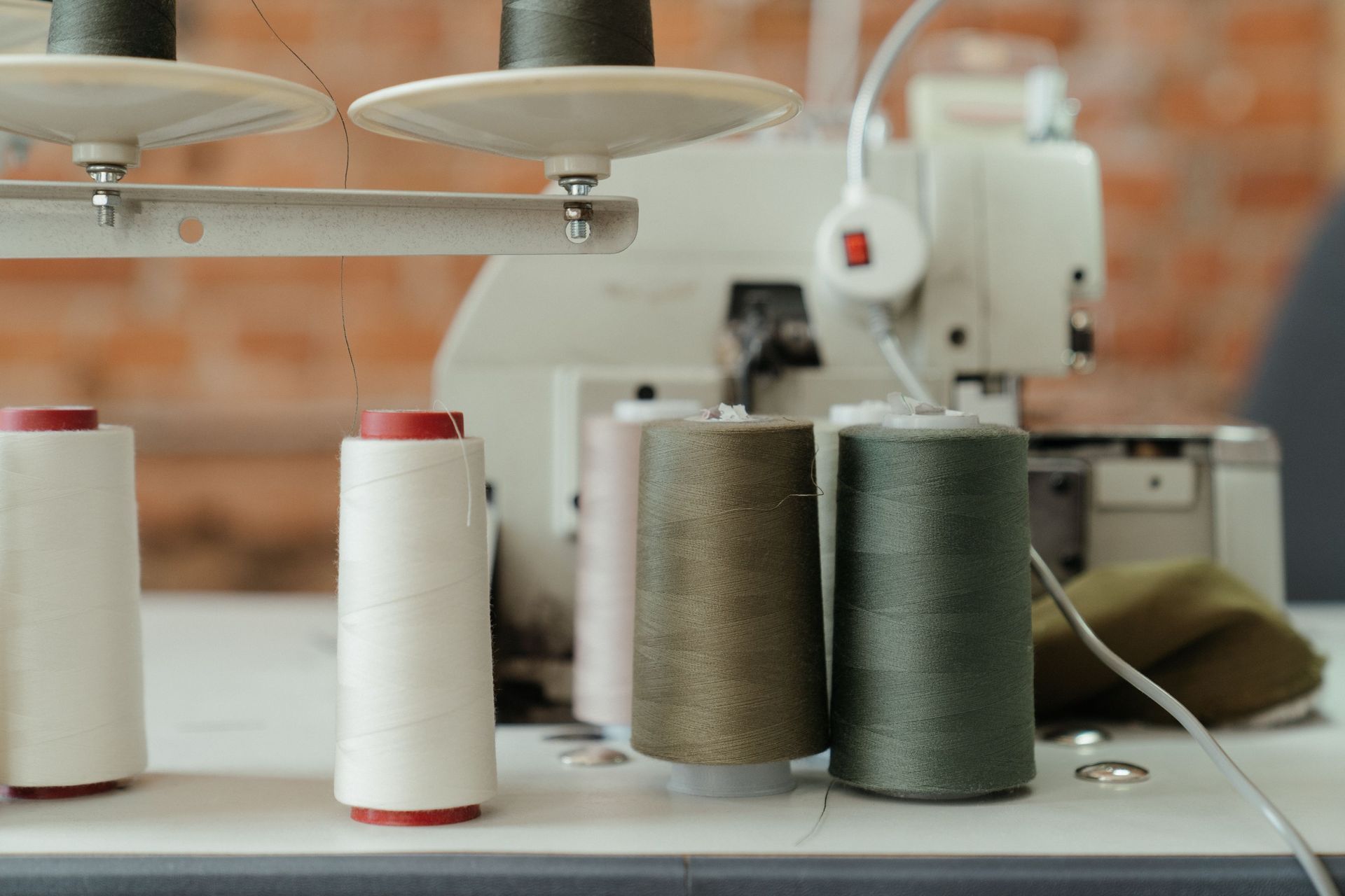 Bobinas de hilo en una máquina de coser en un taller textil.