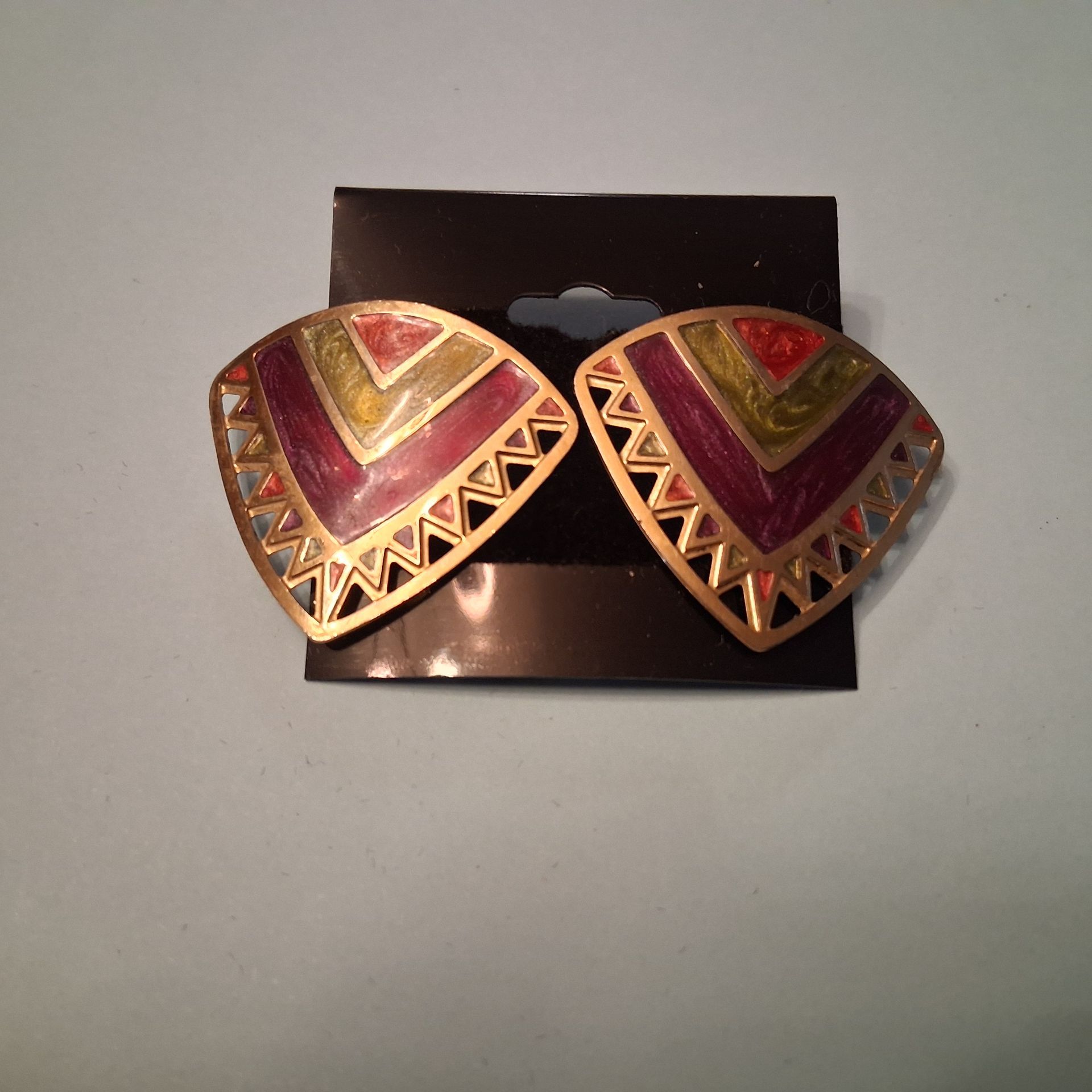 Two decorative earrings with red butterflies on a dark backing card
