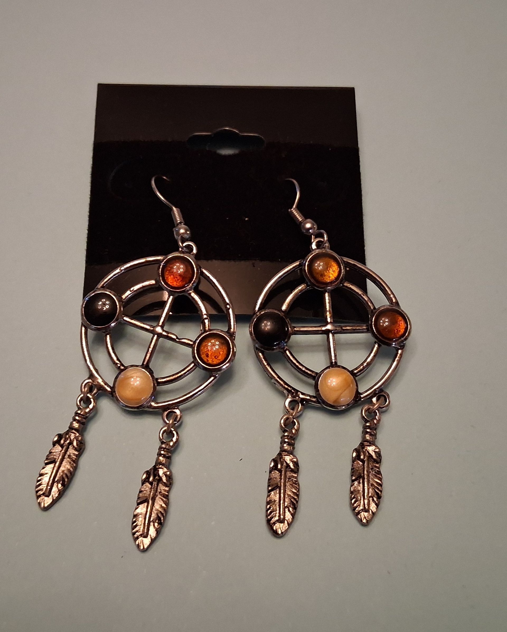 Assorted dangling earrings displayed on black backing cards