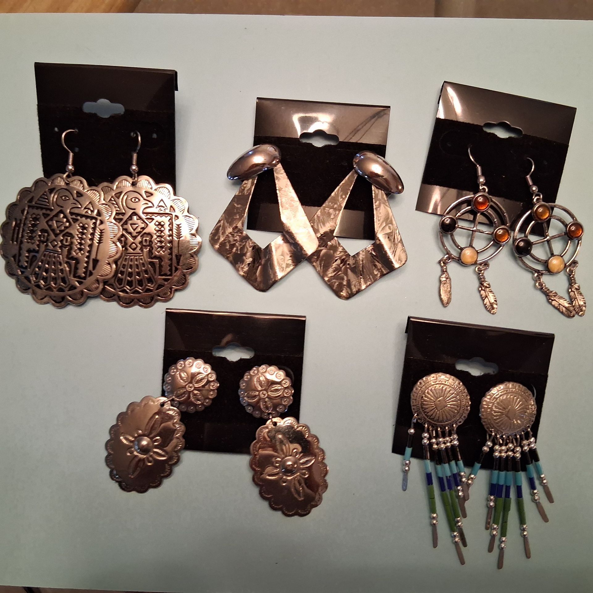 Assorted dangling earrings displayed on black backing cards