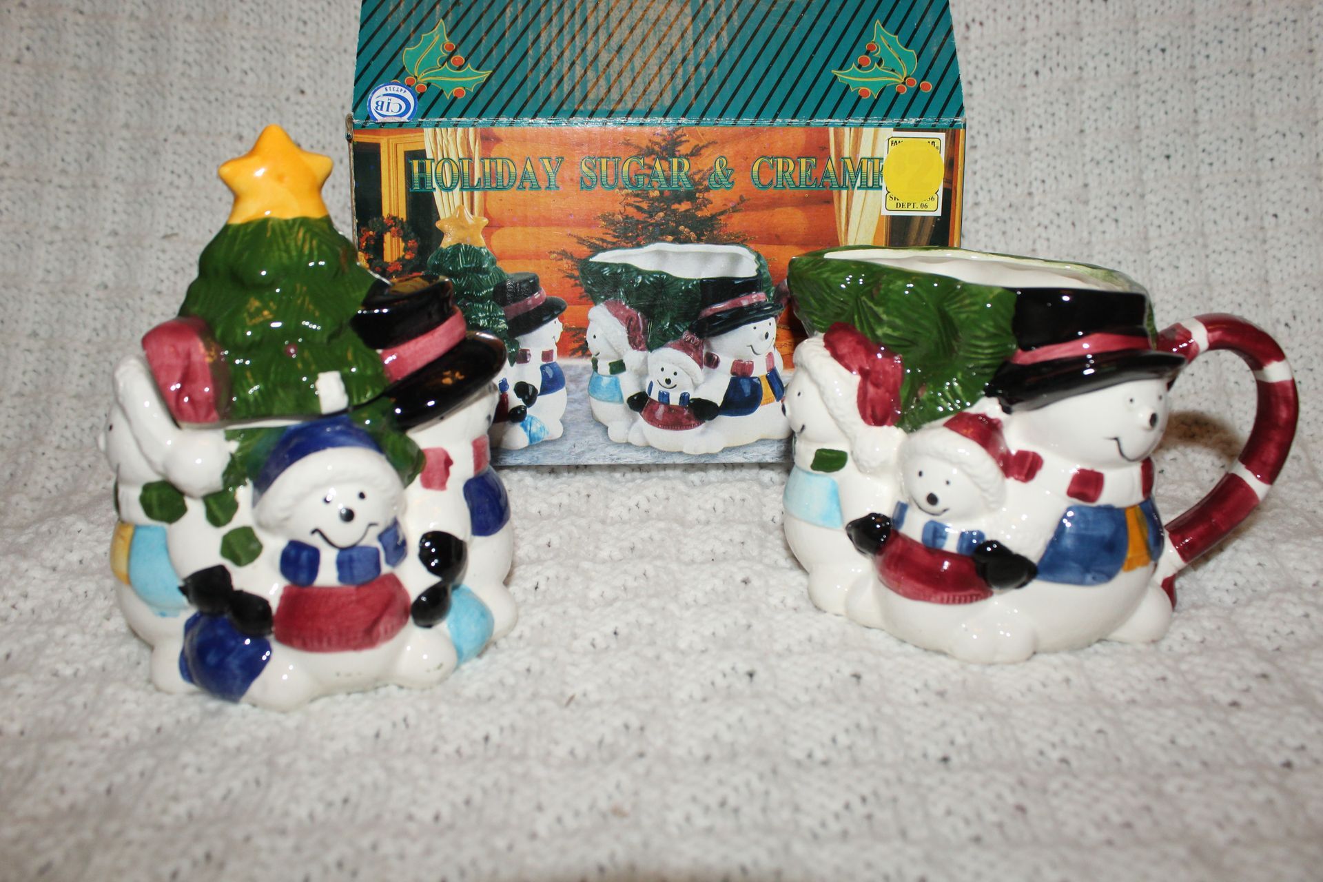 Holiday mug set with snowmen, a Christmas tree, and a decorated festive house