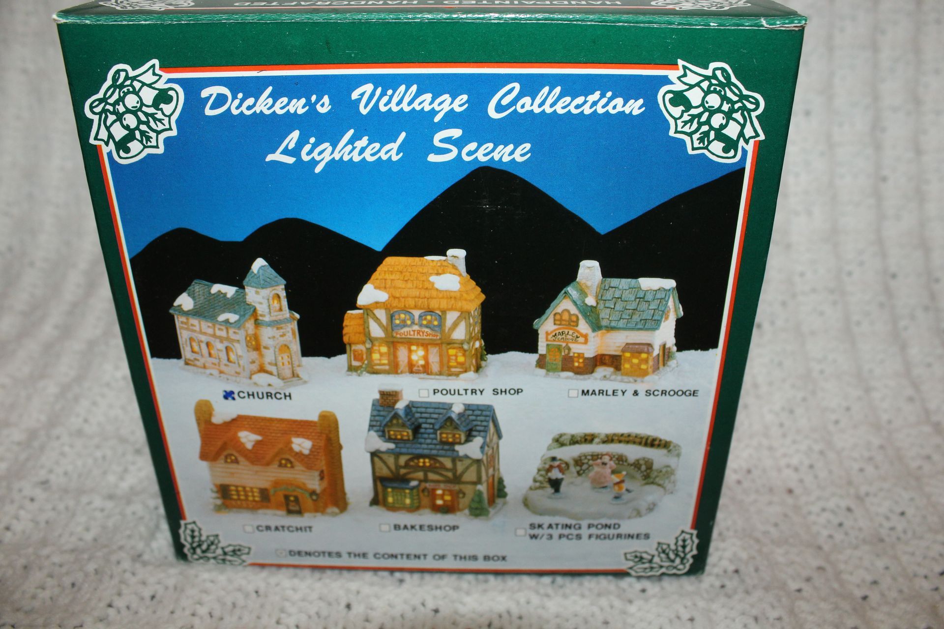 Snow-dusted miniature stone house with a tower, cream walls, and dark roof against a textured white background