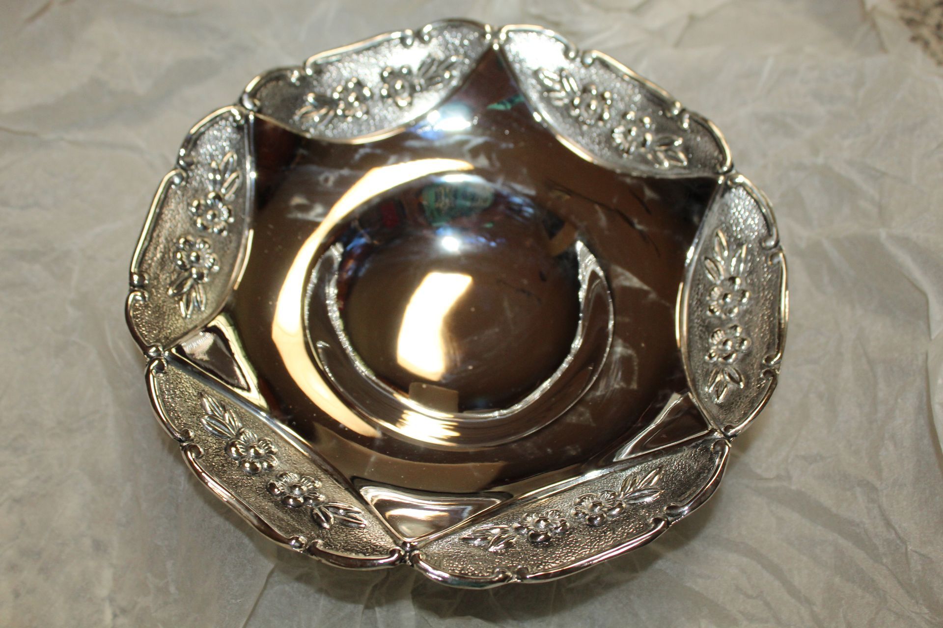 Silver ornate serving dish with scalloped edges and embossed floral details