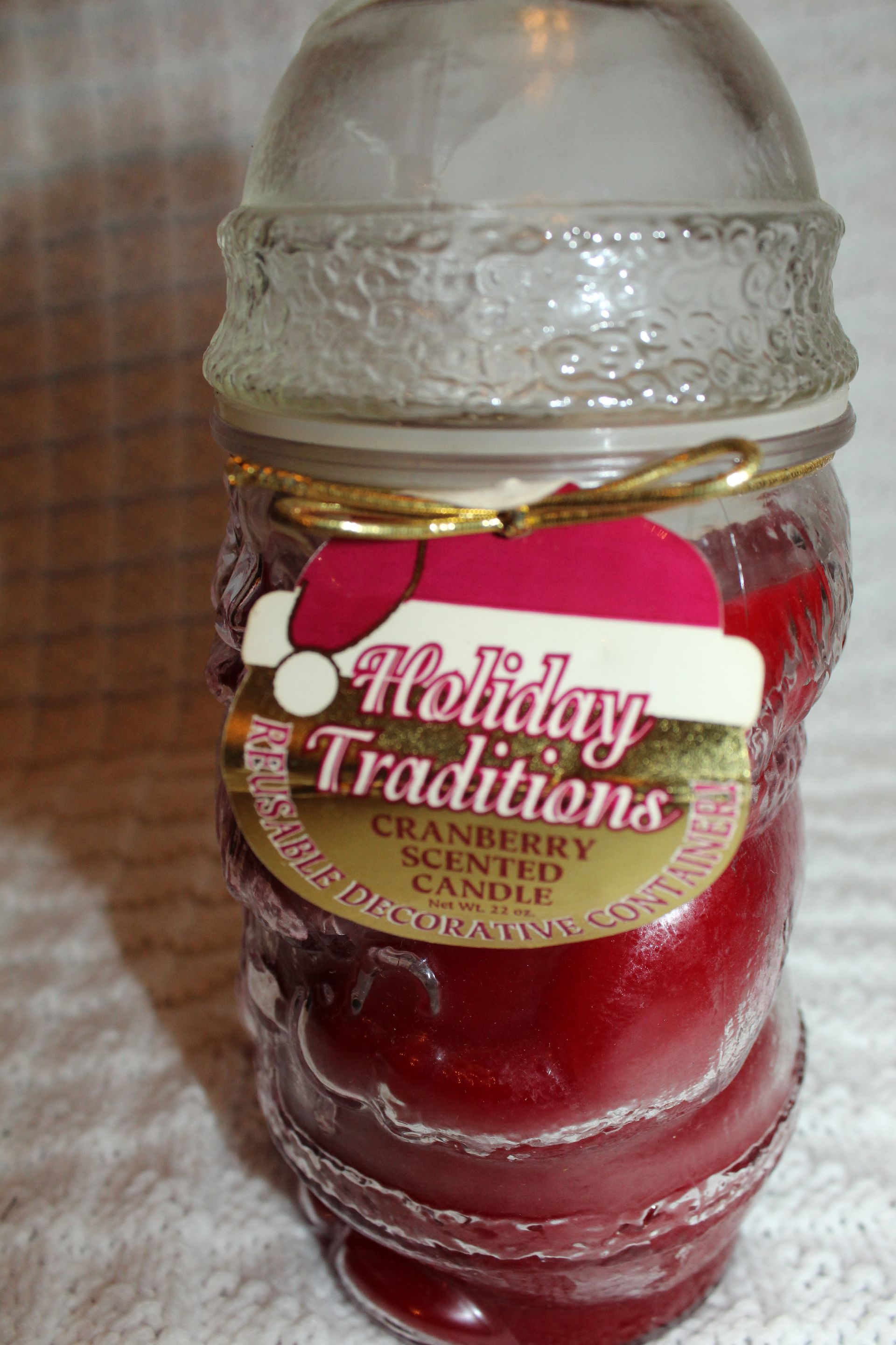 Glass candle jar with red candle and gold Holiday Traditions label