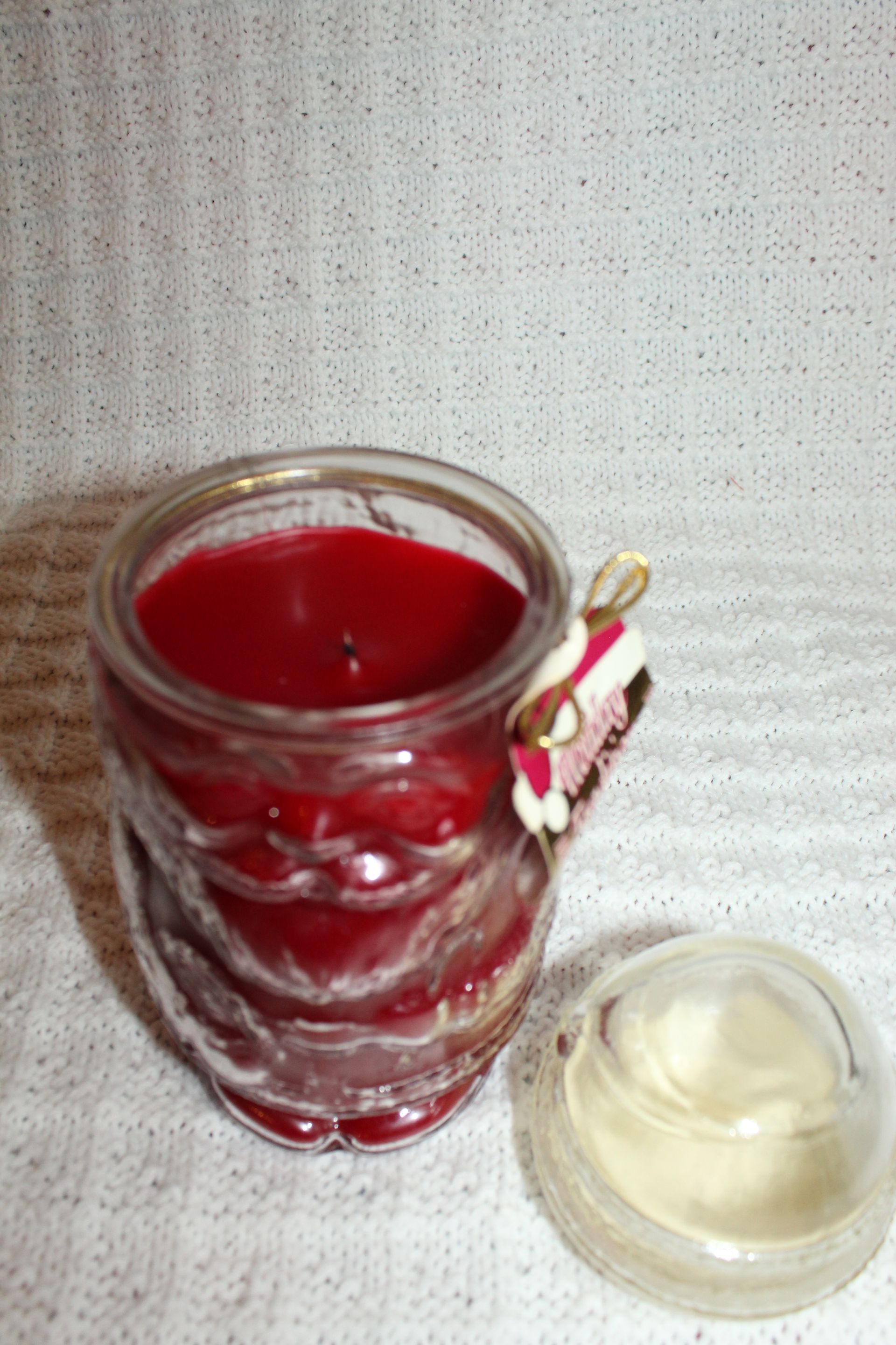 Glass candle jar with red candle and gold Holiday Traditions label