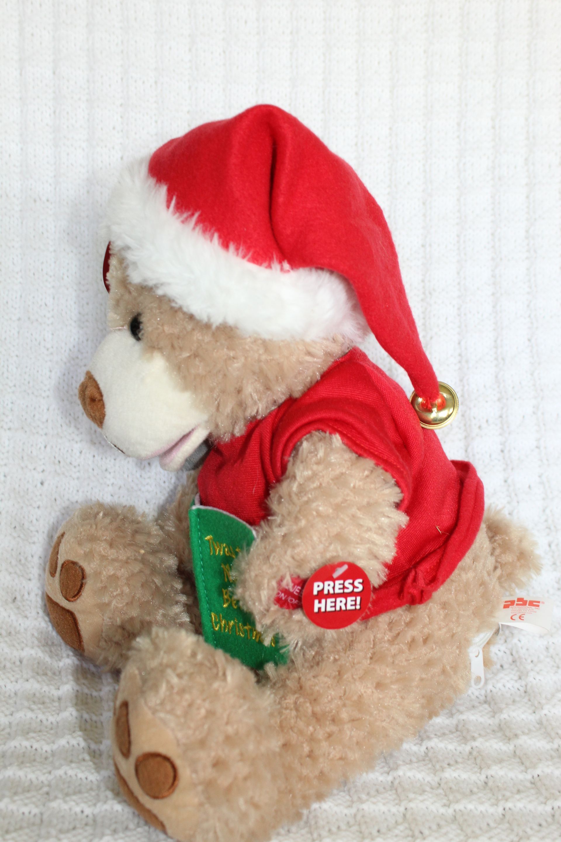 Teddy bear in a red Santa outfit holding a gray koala plush with a green “Winter Wonderland” sign