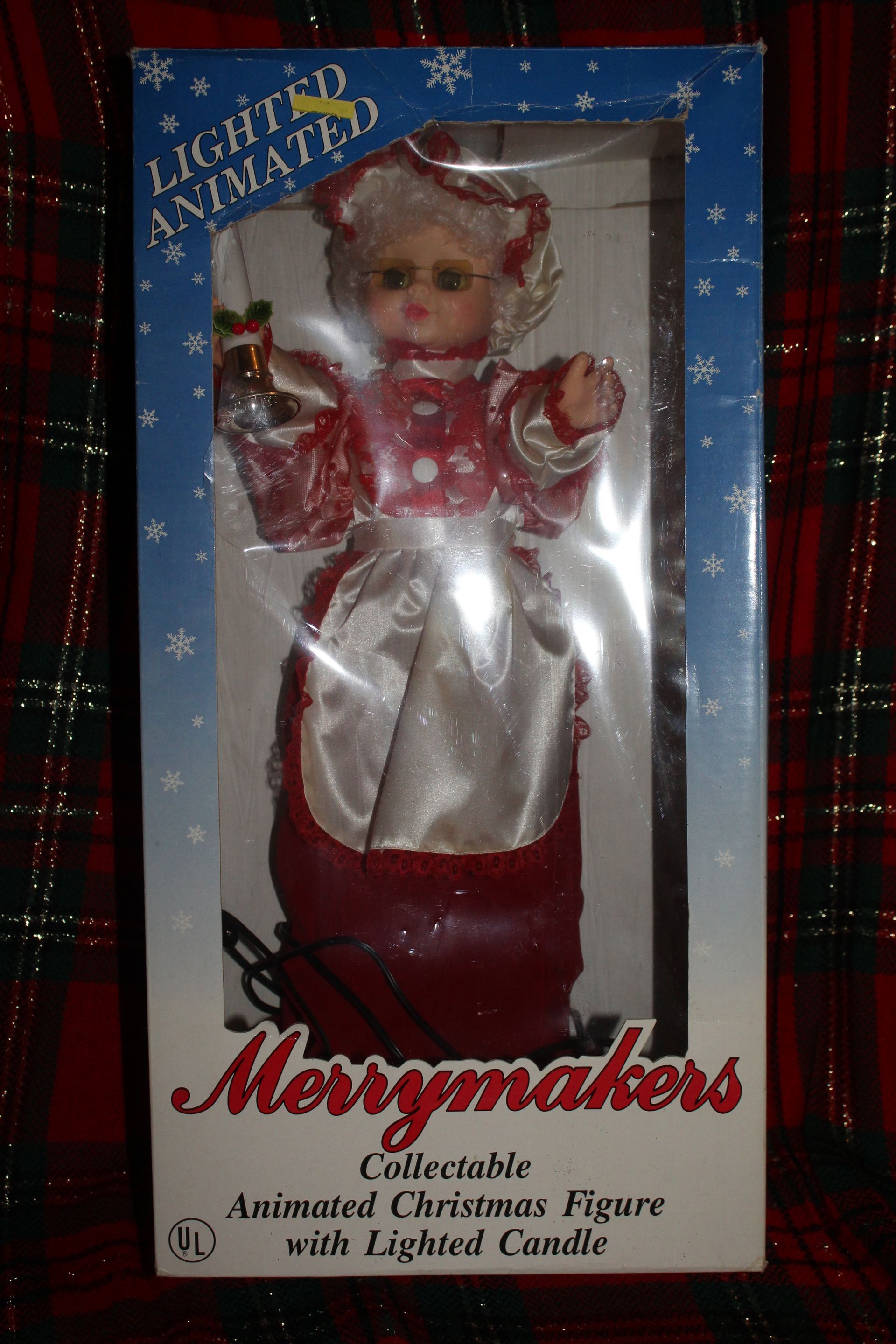 Santa and Mrs. Claus figurines in red outfits, each holding a candy cane, standing on black bases.