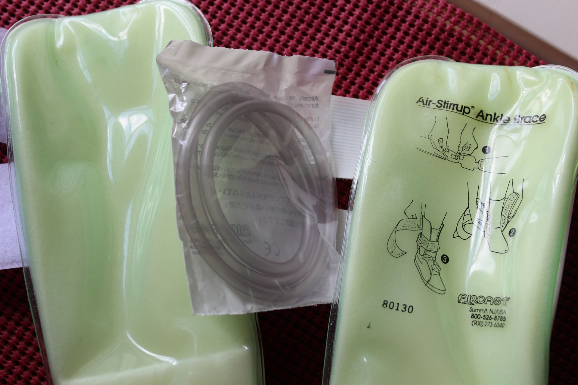 Boxed Airraxx product with white gloves and a clear hose on a beige couch