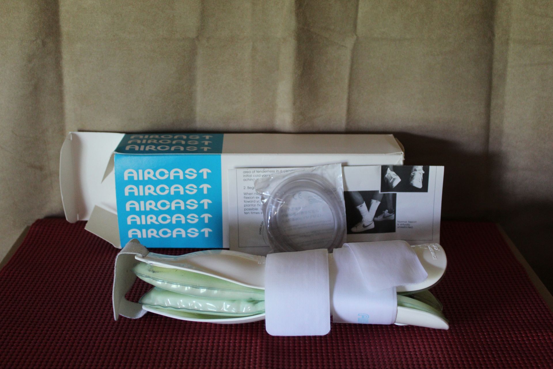 Boxed Airraxx product with white gloves and a clear hose on a beige couch