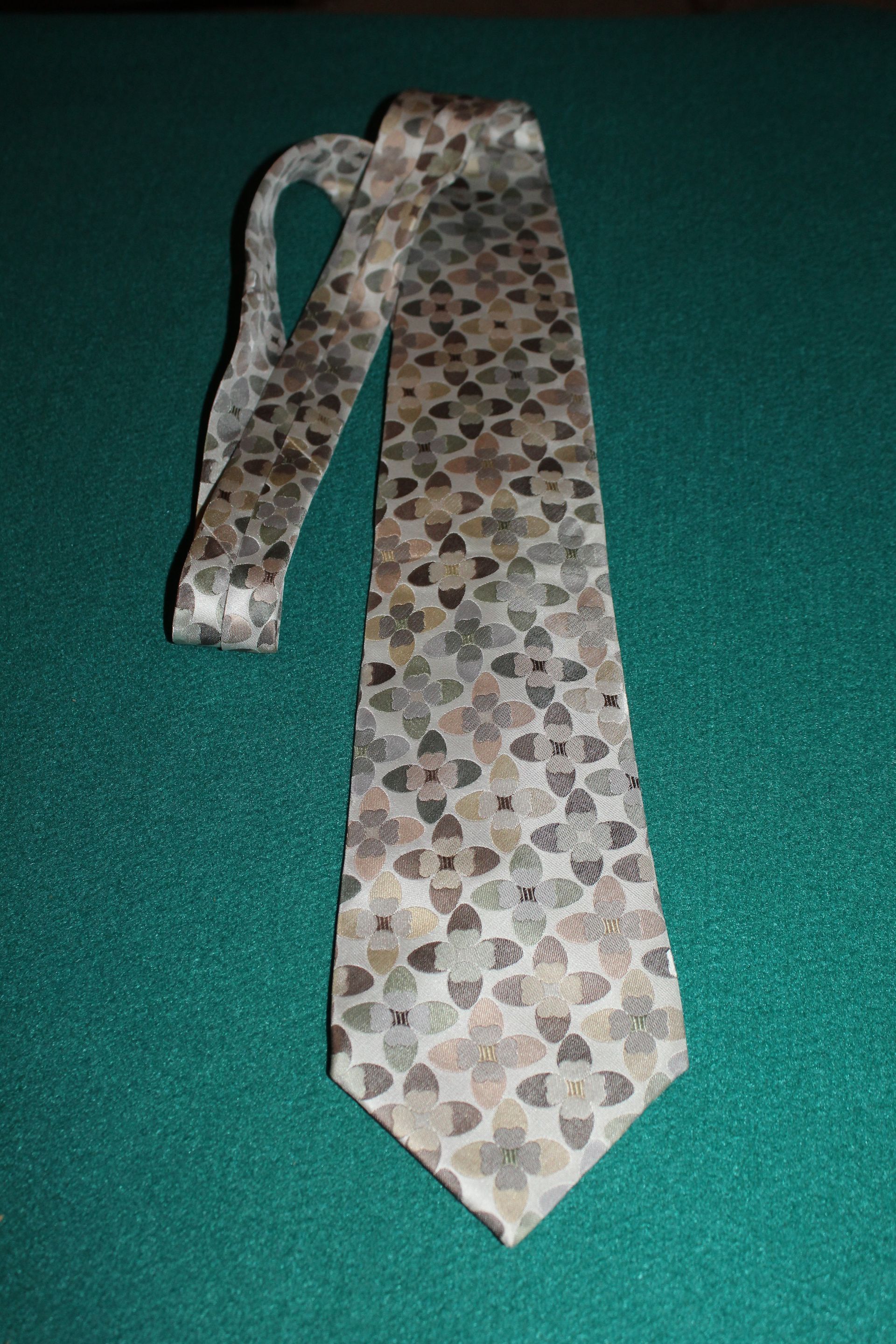 Patterned necktie on a green surface